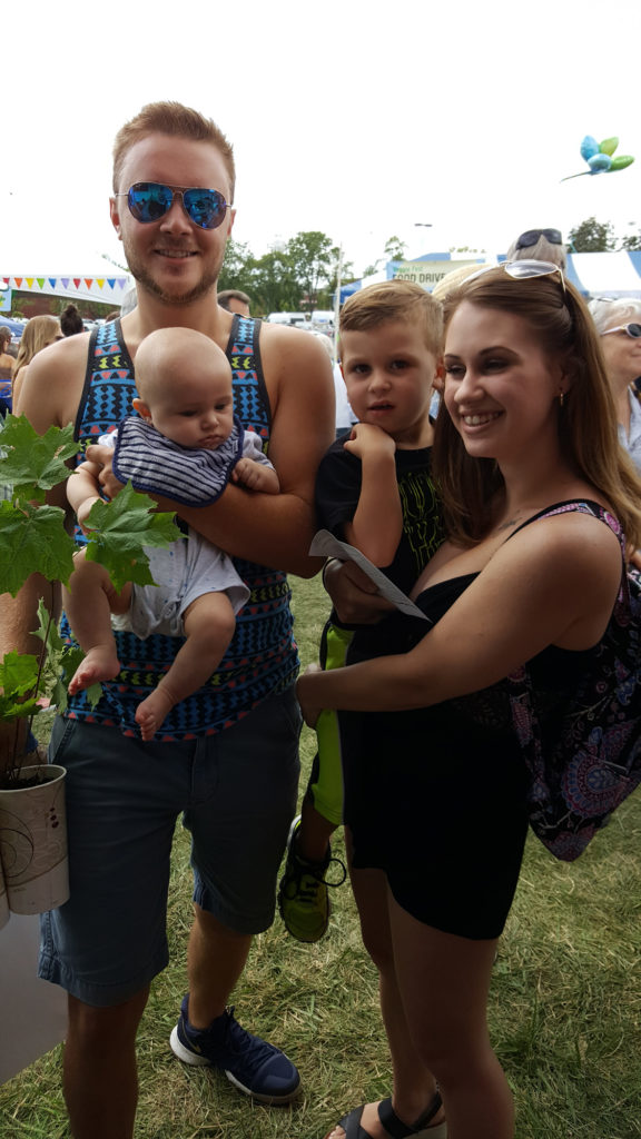 A Mom and Dad with their 2 cute kids and 1 new tree. They'll have their hands full for a while!